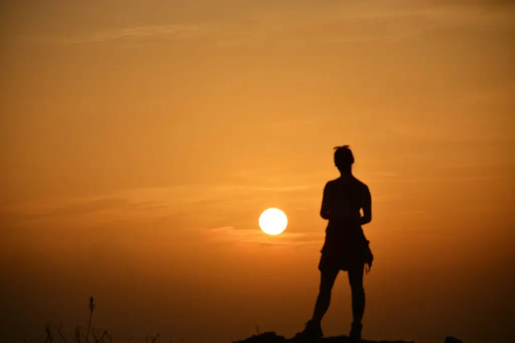 Sunset view at Sipi Falls in Uganda with a person silhouetted against the sky during golden hour in the Sipi Falls Sunset Experience