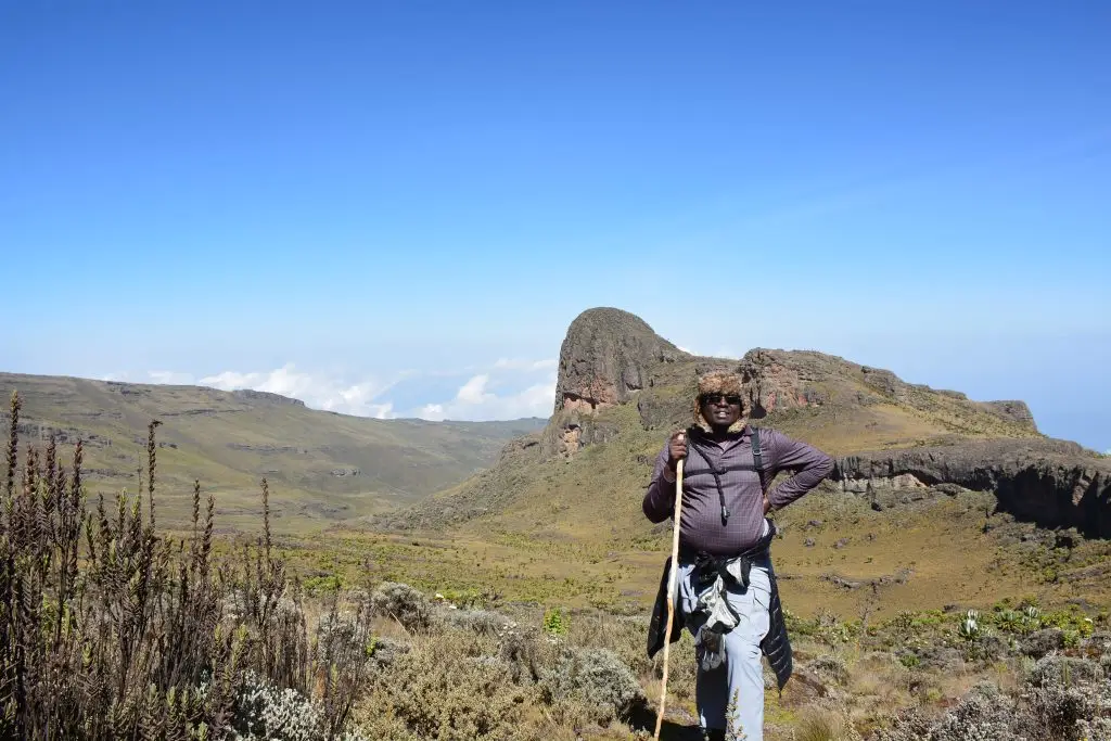 Hiker standing on the high altitude across the Jackson peak and the caldera ridge of Mount Elgon during guided hiking experience
