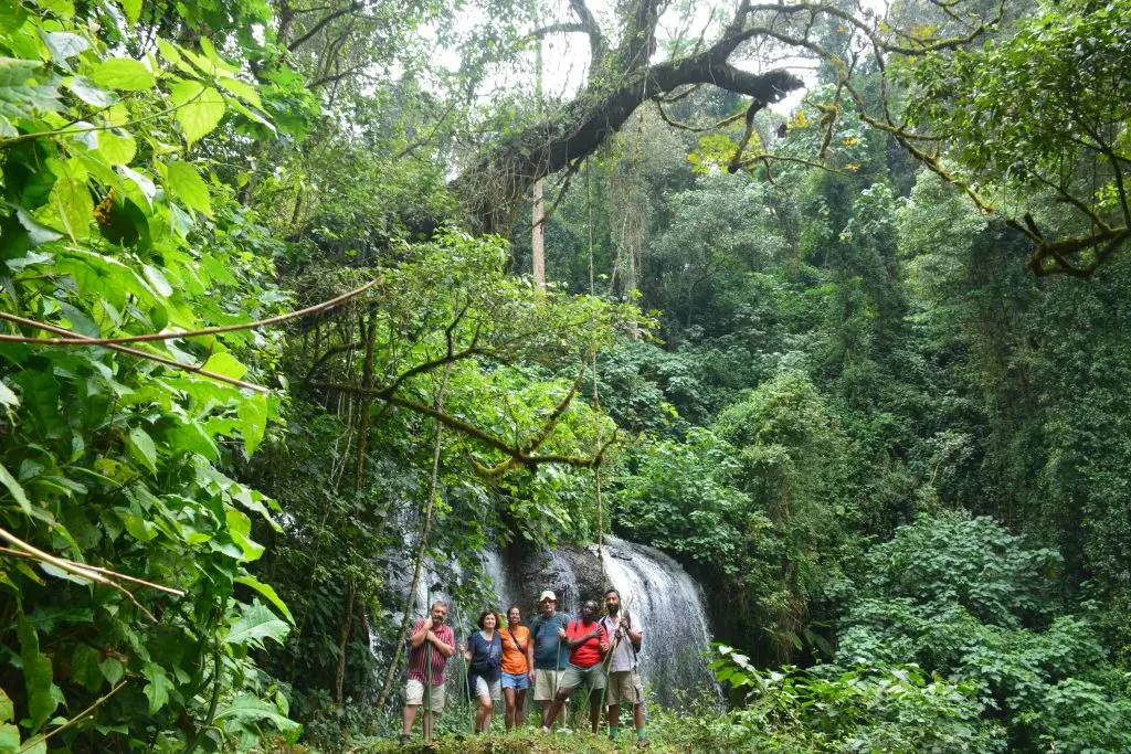 Tourist having a photo at Chebonet Waterfalls during a Mount Elgon nature walk in eastern Uganda