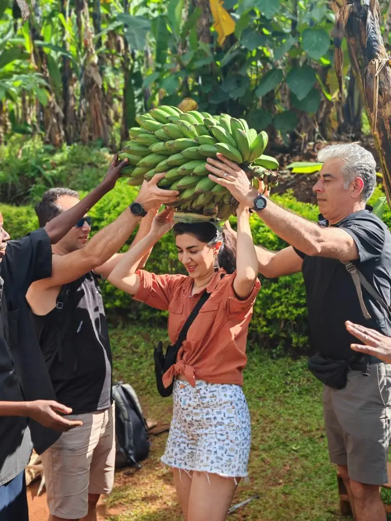 Tourists carrying bananas freshly from the garden during Sipi Local Cooking Experience in Sipi Falls Uganda