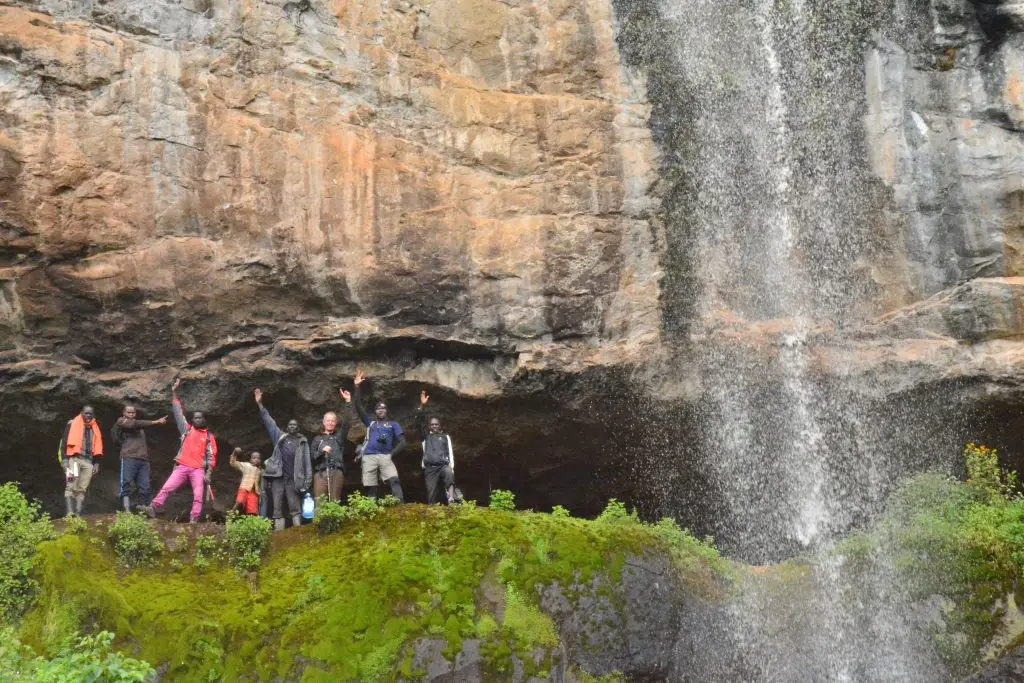Visitors standing inside Mukuuso cave near Mount Elgon during the Ndorobo trail cultural hike