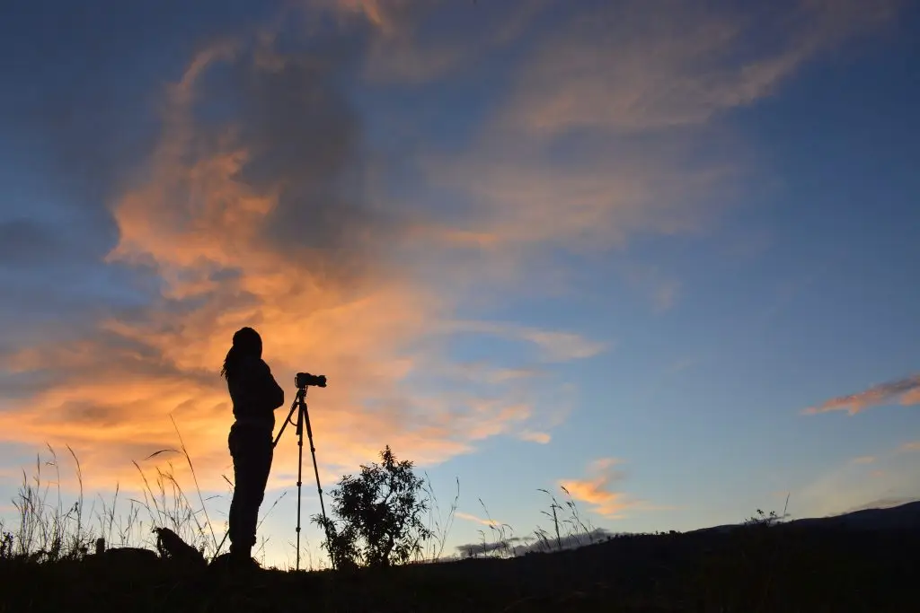 A Photographer capturing sunrise views over Sipi Falls hills with Mount Elgon ranges in Eastern Uganda