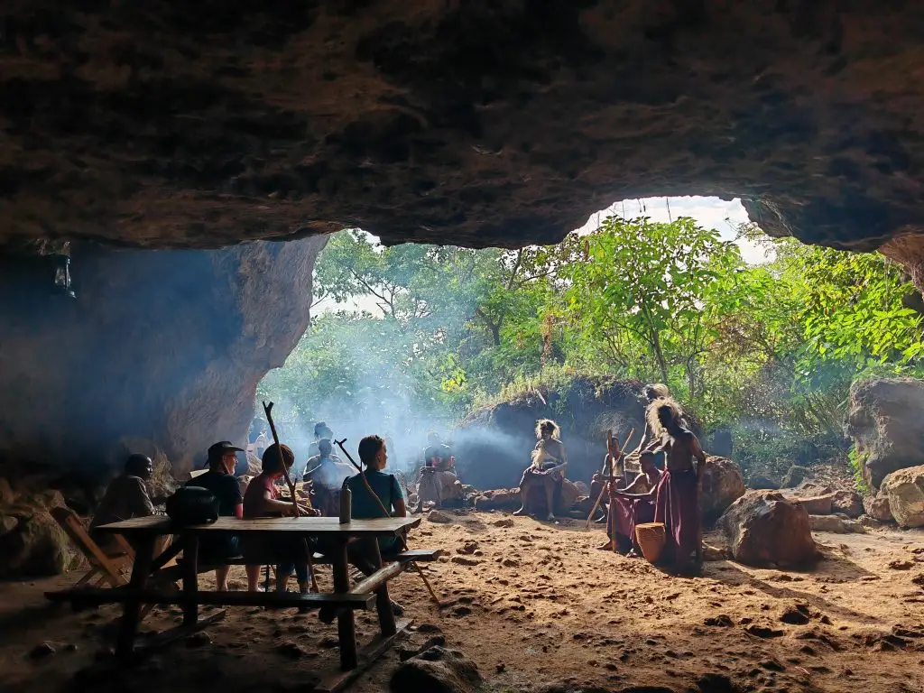 Visitors gathered inside a traditional cave in Sipi Falls during a Sebei Cultural storytelling experience in Mount Elgon, Uganda