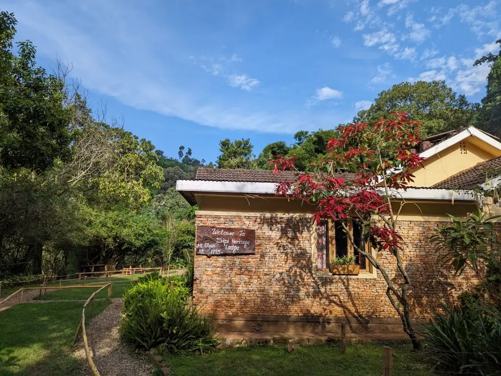 Reception and restaurant building at Sipi Heritage Lodge surrounded by gardens and trees in Sipi Falls, Eastern Uganda.